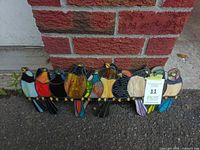 Front view of multicolor stained glass bird panel leaning against brick wall