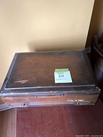 Closed wooden flatware chest showing exterior wear