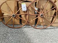 Pair of wooden wagon wheels leaning against cartons