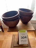 Stacked view of four small wooden bowls