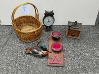 All six items arranged on pavement: basket, owl clock, coffee grinder, reflector board, duck decoy, brass shoehorn
