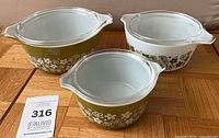 Three Pyrex Spring Blossom casseroles with lids, showing exterior floral patterns