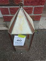 Full view of lantern front showing stained and clear glass panels, hanging ring, wear