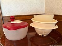 Salad spinner and stacked colander/bowls on wood surface