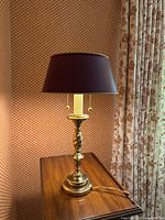Full view of lamp on table showing base, column and shade