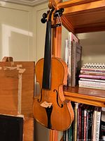 Front view of full-size violin hanging on shelf
