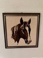 Front view of framed needlepoint horse artwork
