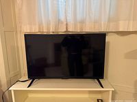 Front view of Insignia TV on stand