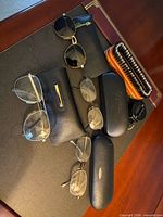 Lot overview showing eyewear, cases, brush and accessory