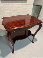 Front three-quarter view showing cabriole legs and lower shelf