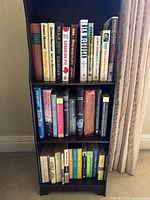 Full view of three-shelf bookcase with all books