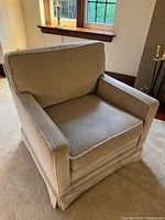 Front and side view of one armchair showing upholstery, arms, cushion and skirt