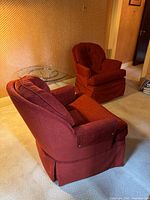 Both red burgundy swivel armchairs side by side