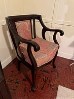 Front three-quarter view of armchair showing frame, upholstery, cabriole legs