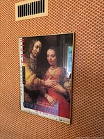 Frontal view of framed Rembrandt exhibition poster on wall