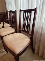 Group view of six mahogany Hepplewhite chairs against drapery