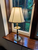 Full view of lamp on windowsill, shade attached and cord visible