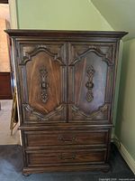 Front view of armoire showing double doors and lower drawers