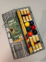 Croquet components arranged in open metal basket