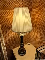 Full view of lamp with shade illuminated on side table