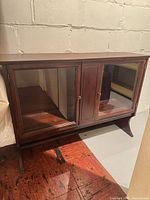 Front view of mahogany console cabinet with glass side doors and center solid door
