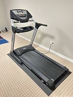 Three-quarter side view of complete treadmill showing console, handrails, deck