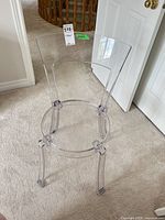 Front view of clear acrylic chair showing overall shape and transparency