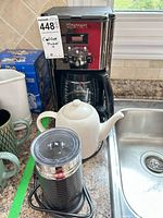 Coffee maker, frother, teapot, mugs grouped on countertop