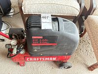 Full view of Craftsman red 3-gallon 2 HP air compressor showing tank, wheels, handle, gauge and wear