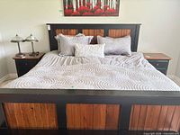 Front view of assembled king bed showing headboard, footboard, mattress and nightstands for scale
