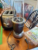 Blender base, cup, toaster, manual on table