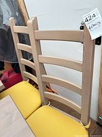Ladder-back wooden dining chairs, lot tag visible