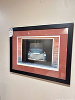 Full view of framed truck print on wall showing frame and mat