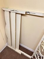 Front and side view of disassembled headboard leaning against wall
