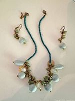 Full view of necklace and earrings set laid flat