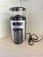 Front view of Espressione burr grinder showing bean hopper, grounds container and power cord