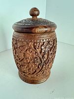 Front view of carved wooden jar with lid