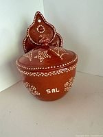 Front view showing full salt cellar, lid, decoration, and hanging plate