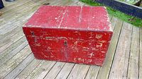 Overall view of red wooden trunk showing front and top surfaces