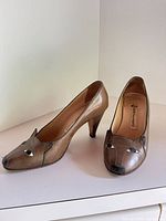 Full view of both shoes showing cat face design, colour and heel style