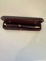 Pen resting inside open wooden case
