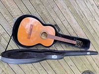 Guitar in open hard case showing overall condition and included case