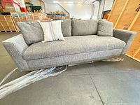 front view of gray four-seater sofa with throw pillows