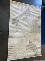 Full view of rectangular beige and gray geometric striped rug