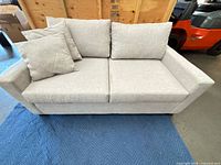Front view of light gray loveseat sleeper with cushions