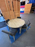 round wooden dining table with four gray chairs