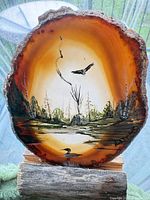 Front of agate slice showing detailed painted landscape and birds in wooden base