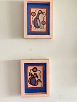 Both framed artworks hanging on wall