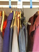Row of assorted coats on hangers displaying colors and materials