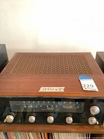 Front and top view of McIntosh MR74 tuner showing wood cabinet, glass face, knobs, ventilation grille